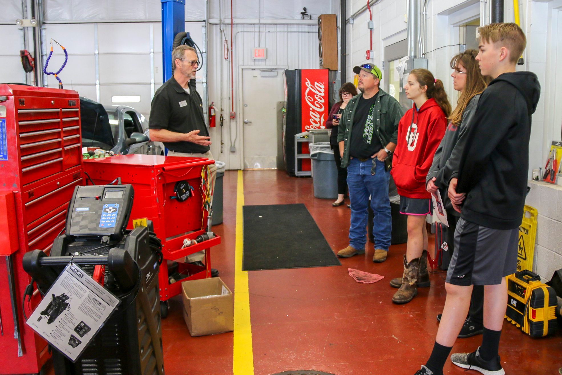 Students and parents touring a mechanic garage